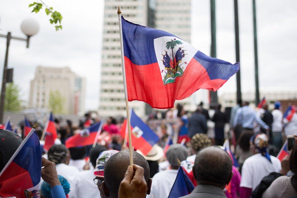 (People raising the Haitian flag — symbolizing resilience, unity, and national renewal.